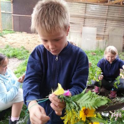 Junge bastlt an Blumenkranz